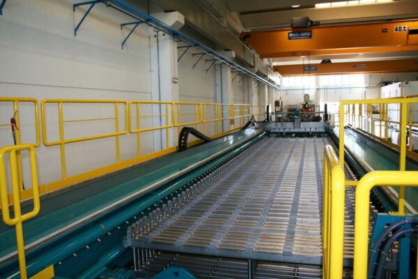 Conveyor system transporting dewatered sludge at refinery facility
