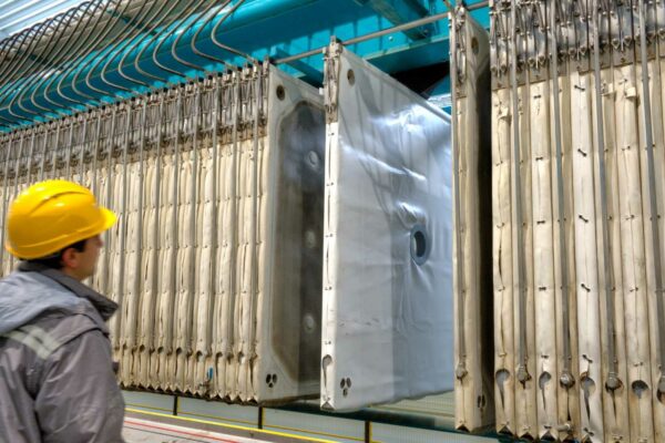 Worker inspecting filter presses during sediment dewatering operations